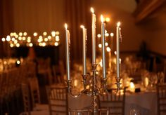 candles are lit in the middle of a banquet table