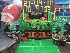 a football themed booth at an event with balls and snacks on the sidelines, in front of a backdrop that says go team down