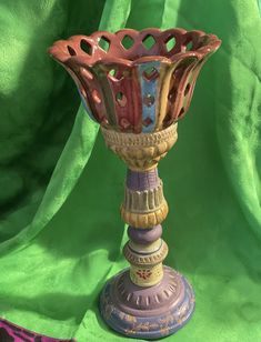 a decorative vase sitting on top of a green cloth