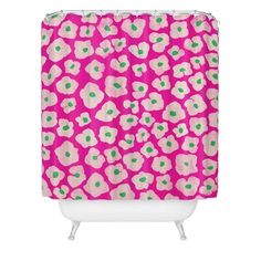 a pink shower curtain with green polka dots and hearts in the center on a white background