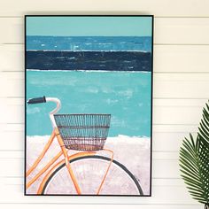 an orange bicycle with a basket on the beach