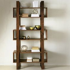 a wooden shelf with books and bowls on it