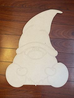 a paper cut out of a gnome sitting on top of a wooden floor