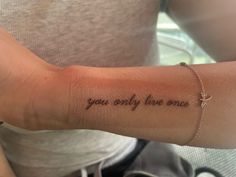 a woman's arm with the words you only live once written in cursive font