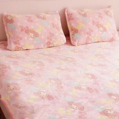 a bed with pink sheets and teddy bears on it