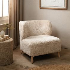 a white chair sitting next to a window in a living room