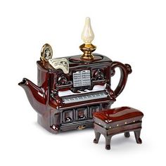 an old fashioned teapot with a piano and footstool in front of it