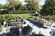 an outdoor living area with couches, tables and chairs in the middle of it