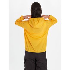 the back of a woman's yellow jacket with her hands on her hips, looking down