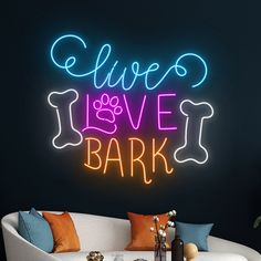 a living room with a couch, coffee table and neon sign that says live love bark