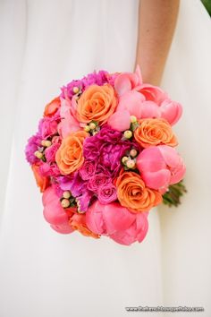 the bride's bouquet is made up of pink and orange flowers