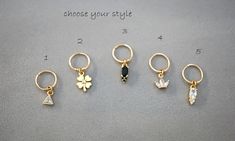 four different types of rings with charms attached to them, all in gold and black