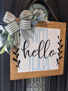 a wooden sign that says hello there with a bow on it's front door