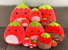 a pile of stuffed strawberries sitting on top of a couch next to each other