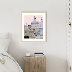 a bedroom with a white bed and a painting on the wall