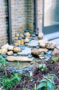 a rock garden in front of a brick building