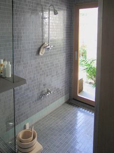 a bathroom with a glass shower door and tiled walls