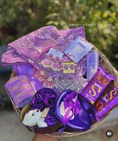 a basket filled with assorted candy and candies on top of a person's hand