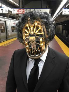 a man in a suit and tie is wearing a mask with an animal on it