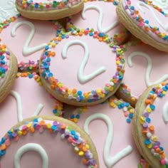 decorated cookies with white icing and colorful sprinkles are arranged in the shape of numbers