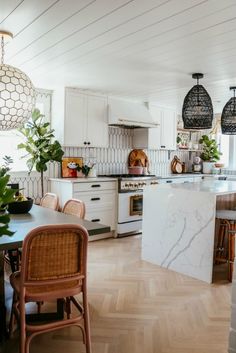 the kitchen is clean and ready to be used for cooking or eating, with white cabinets and marble countertops