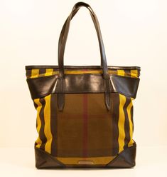 A Burberry tote made of multicolor canvas with black leather trim. The interior is lined with yellow synthetic fabric, and next to the major compartment it features three side pockets of which one has a zipper. The bag is in good condition with signs of use such as scratches on the leather trim, please see the detailed picture of the front upper leather trim.  No dust bag.   Measurements Width: 32 cm Height: 36 cm Depth: 10 cm Handle drop: 21 cm Handle length : 48 cm We ship within 1-3 working d Coated Canvas Bags With Lined Interior For Shopping, Modern Bag With Lined Interior, Coated Canvas Shopping Bags With Lined Interior, Shopping Bags With Lined Interior In Coated Canvas, Shopping Bags With Lined Interior And Coated Canvas, Daily Use Coated Canvas Shoulder Bag With Lined Interior, Designer Brown Bag With Canvas Lining, Yellow Coated Canvas Shoulder Bag For Travel, Travel Bags With Fabric Lining And Canvas Material