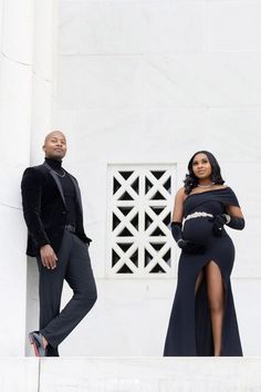 a man and woman standing next to each other in front of a white building with columns