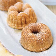 three donuts on a plate with powdered sugar