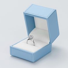 an open blue box with a diamond ring inside