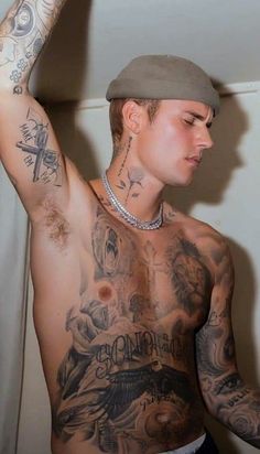 a man with tattoos on his chest and arm