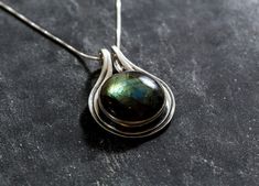 Labradorite Necklace set with a Natural Labradorite in a beautiful iridescent play of green/brown/blue color, at 18mm diameter (20 Cts) from Madagascar.Solid 925 Sterling Silver ☞ made to last.Click here for ☞ Statement Jewelry CollectionMatching Earrings & Matching Rings ☞ please ask meDetails:• Natural Labradorite sourced from Madagascar• Labradorite: 18mm, 20 Cts, cabochon cut• Dimensions: Pendant Height 32mm, Width 22mm• Free Complimentary Chain• Solid 925 Sterling Silver❀ Each Natural Gem i Labradorite Necklace, Matching Ring, Labradorite Necklaces, Sapphire Pendant, Cabochon Pendant, Statement Pendant, Matching Rings, Labradorite Pendant, Pendant Design