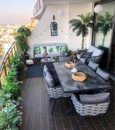 a table and chairs on a balcony with potted plants