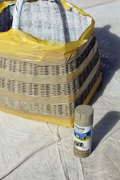 a wicker basket sitting on top of a table next to a paint can and brush