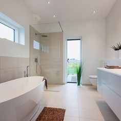 a bathroom with a large bathtub next to a walk in shower and two sinks