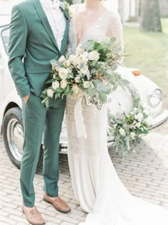 a man and woman standing next to each other in front of a car