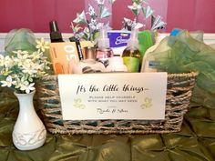 a basket filled with lots of different items on top of a green table cloth covered bed