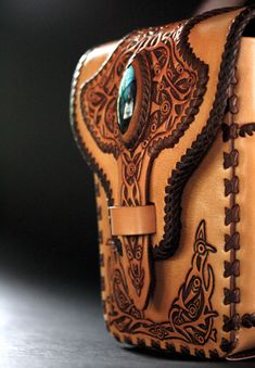 an intricately decorated brown leather case on a table