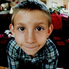 a young boy is smiling for the camera