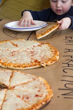 a young boy eating pizza from a cardboard box