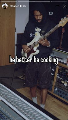 a man standing in front of a mixing board with an electric guitar