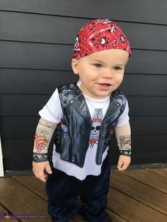 a little boy wearing a red bandana and leather vest with tattoos on his arms