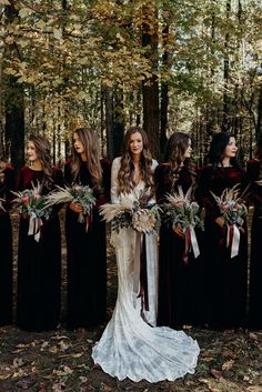 a group of women standing next to each other in front of trees with long hair