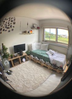 a room with a bed, desk and television in the corner is seen through a fish eye lens