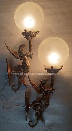 two wall sconces with lights attached to them