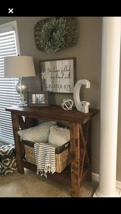 a wooden table with baskets underneath it and a lamp next to it on the floor