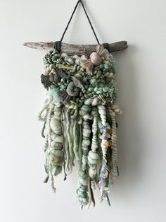 a piece of driftwood hanging on a wall with sea shells and seashells