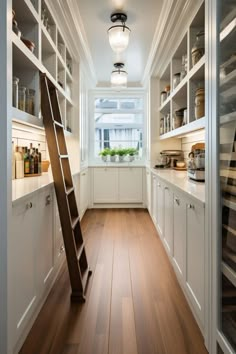 a ladder is in the middle of a kitchen with white cabinets and shelves on both sides