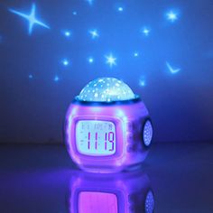 an alarm clock is sitting on the floor in front of a blue background with stars