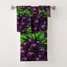 a towel hanging on the side of a wall with grapes and leaves printed on it