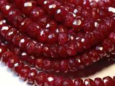 red glass beads with white speckles are on the table next to each other